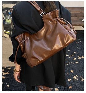 Close-up of caramel brown oil-wax leather tote bag with drawstring detail for women