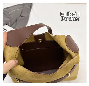 Detail of the yellow suede bucket bag interior featuring a brown leather inner pocket
