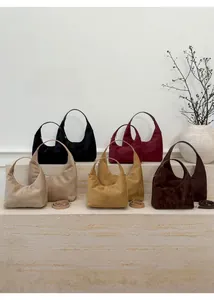 Detailed view of suede-textured dumpling bags in multiple retro autumn colors