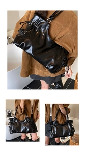 Detail of a large black wax leather tote with drawstring pleats and glossy finish
