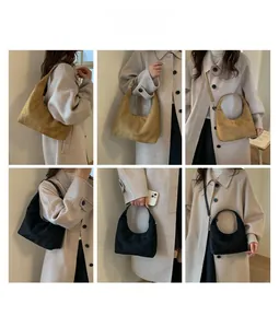 Detail showing khaki and black suede dumpling bags worn as crossbody and shoulder styles