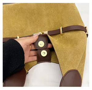 Detail of magnetic buckle closure on ginger suede and brown leather tote bag