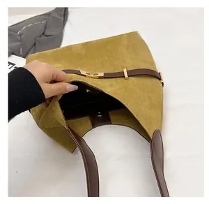 Detail view of mustard suede tote bag showing magnetic buckle and spacious interior