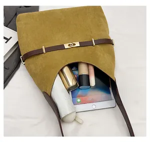 Interior view showing the large capacity of the mustard suede bucket bag with daily items