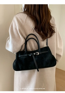 Détail du sac à main en daim noir avec boucle argentée et design rétro minimaliste sophistiqué