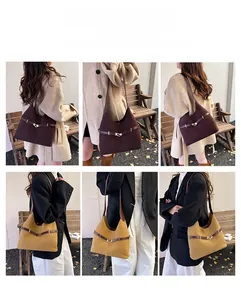 Detail of suede hobo bucket bag in brown and yellow with metal buckle and multiple straps