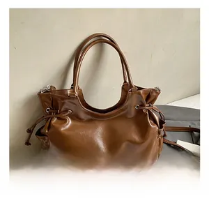 Macro detail of brown leather tote bag with drawstring closure and side pockets