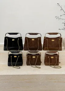 Quilted bucket bags in various sizes and colors displayed on stone stairs with gold chains