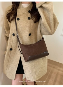 Detail of dark brown retro suede crossbody bag with minimalist shoulder strap design