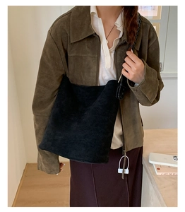 Détail du grand sac hobo en daim noir avec une texture mate douce et un design spacieux