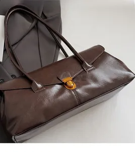 Close-up of dark brown PU leather shoulder bag featuring a golden twist-lock closure