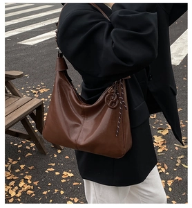 Photo de rue d'un sac à bandoulière vintage en cuir caramel avec une finition cirée brillante