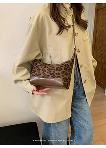 Detail view of leopard print baguette bag with brown leather base and retro vibe