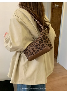 Detailed side view of leopard print baguette bag with premium leather bottom stitching