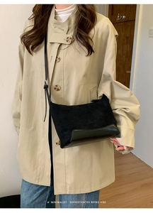 Detail of black suede and leather patchwork crossbody bag on trench coat model