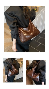 Détail du sac hobo en cuir marron vintage avec côté tressé et large bandoulière réglable