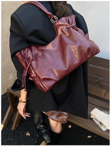 Detail of burgundy waxed leather tote bag showing fine drawstring and silver ring buckle