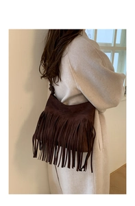 Détail du sac bandoulière en daim marron foncé avec de longues franges et nœud