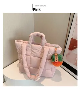 Detailansicht der rosa gesteppten Puffer-Tasche mit dekorativem Plüsch-Anhänger