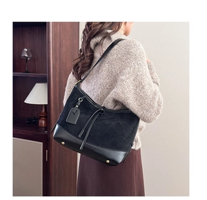 Detail of vintage matte black shoulder bag with gold protective studs and mixed textures