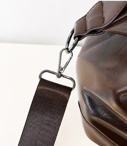 Dettaglio del gancio in metallo e della tracolla in nylon della borsa marrone