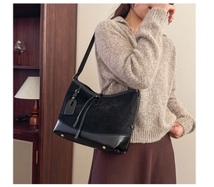 Detail of vintage matte black contrast shoulder bag with gold hardware and side rivets