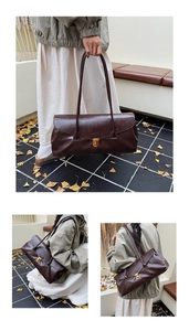 Detailed outdoor shot of a brown vintage leather shoulder bag with gold metal buckle