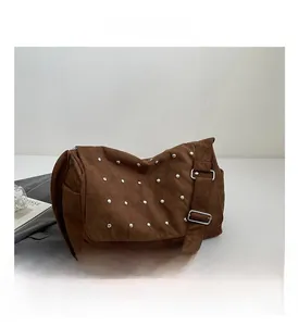 Détail du sac à main en daim marron rétro avec rivets argentés et bandoulière large