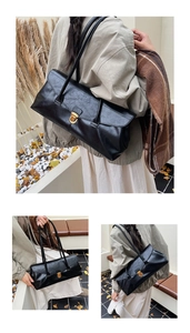 Detail of minimalist black PU leather shoulder bag with vintage gold metal buckle
