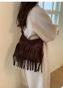 Détail du sac à bandoulière en daim marron foncé avec de longues franges et bandoulière nouée