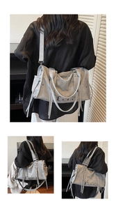 Macro view of grey motorcycle bag featuring vintage rivets, fringe details and buckles