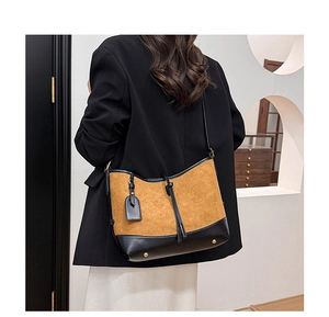 Détail du sac cabas en patchwork de daim avec clous de protection et étiquette en cuir