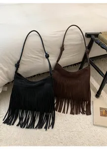 Détail de sacs à bandoulière vintage en daim à franges noir et marron avec nœuds de sangle