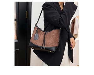 Détail du sac fourre-tout en daim avec franges et base en cuir noir renforcé