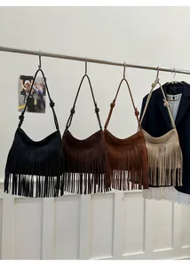 Vier Boho-Fransentaschen in Schwarz, Braun, Karamell und Beige an einer Kleiderstange
