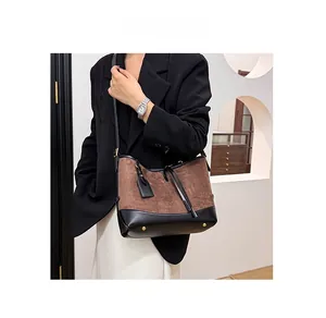 Detail of vintage brown suede and black leather shoulder bag with golden metal feet