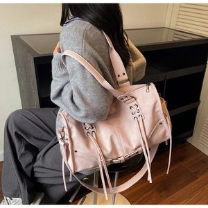 Vue arrière du sac cabas en cuir rose avec détails lacés et longs glands sur mannequin