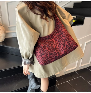 Detail showing high-capacity burgundy leopard print hobo bag worn with a khaki coat