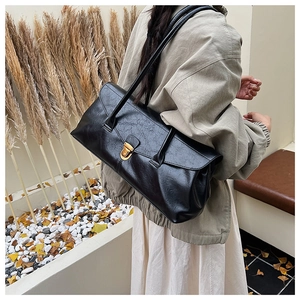 Detail view of large black retro hobo bag with gold metal buckle and textured finish