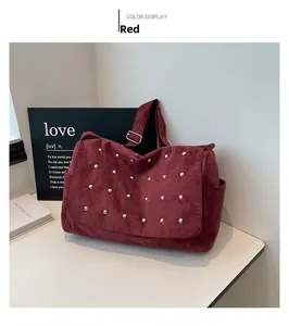 Sac à main rouge en daim avec clous argentés et large bandoulière décoré