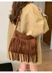 Detail einer braunen Retro-Wildledertasche mit langen Fransen und schlichtem Schultergurt