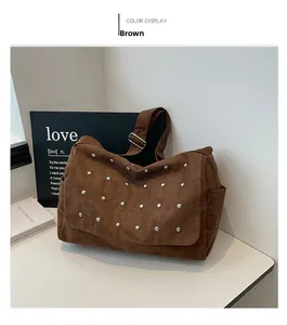 Gros plan du sac en daim marron montrant les rivets et les détails métalliques
