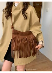 Gros plan détaillé d'un sac bandoulière en daim marron foncé avec de longues franges