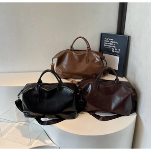 Gros plan de trois grands sacs cabas en cuir texturé noir, marron et café foncé