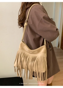 Detail shot of beige faux suede tassel bag with a minimalist bohemian retro design