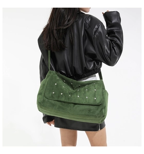 Vue détaillée du grand sac vert foncé à rivets porté avec une veste en cuir noir