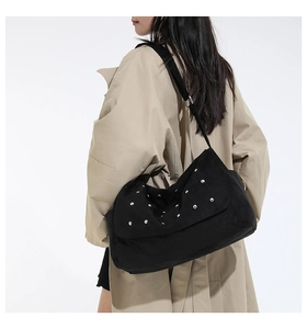 Détail du sac à bandoulière noir avec clous argentés et texture mate élégante