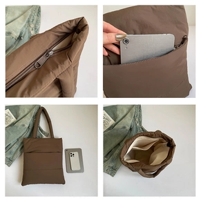 Close-up of brown quilted tote bag showing zipper detail, storage pockets and interior layout