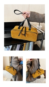 Detail of yellow suede handbag with black handles and golden metal twist lock buckle