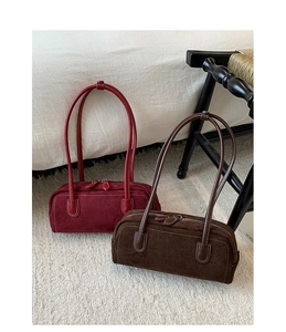 Detail of vintage suede Boston bags in deep red and coffee with contrast stitching